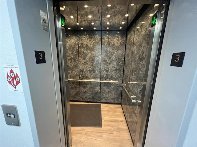 interior space with elevator and hardwood / wood-style flooring