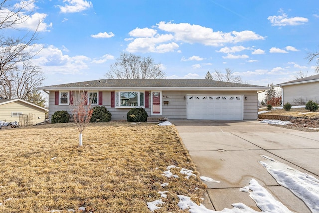 single story home with concrete driveway, a garage, and a front lawn