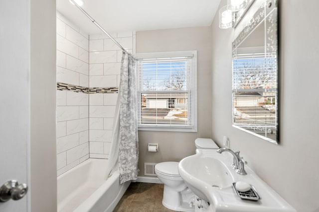 bathroom featuring baseboards, visible vents, tile patterned flooring, shower / bath combination with curtain, and toilet