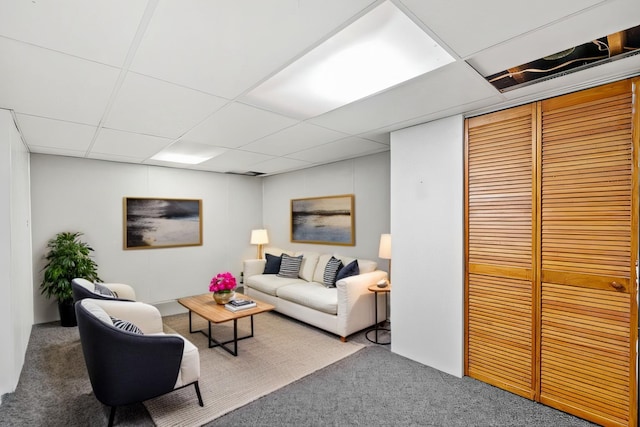 carpeted living room with a drop ceiling