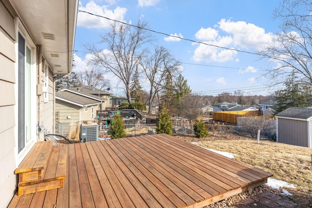 wooden deck with an outbuilding, a shed, cooling unit, and visible vents