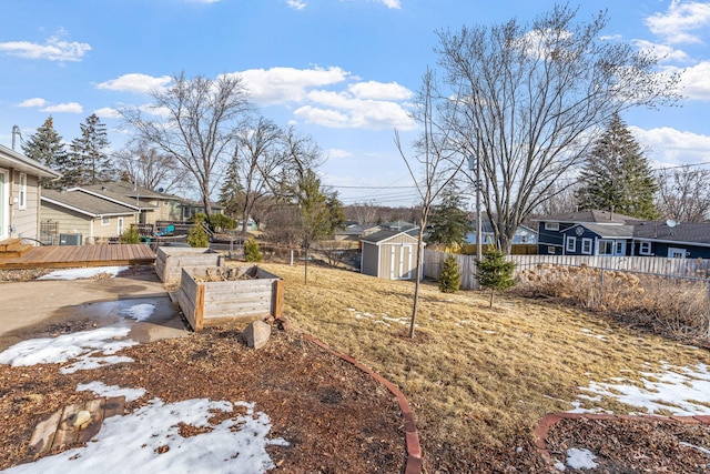 view of yard featuring an outbuilding, a shed, fence, a garden, and a wooden deck