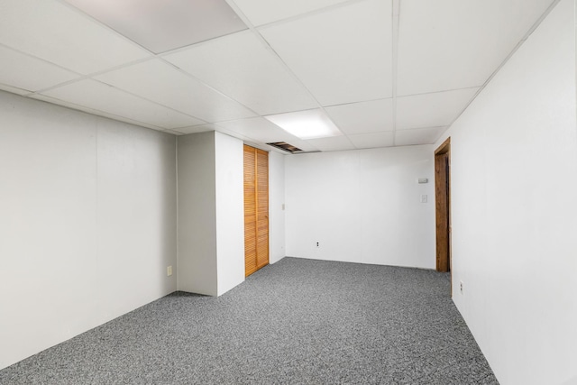 finished basement featuring a paneled ceiling, visible vents, and carpet floors