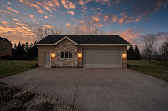 view of front of property with a garage and a lawn