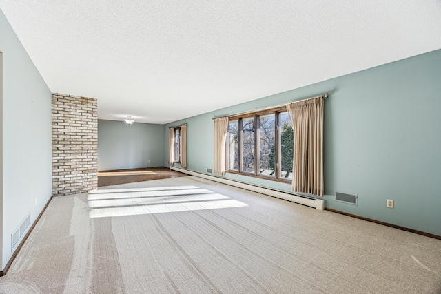 carpeted empty room with a textured ceiling and baseboard heating