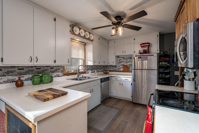 kitchen with sink, dark wood-type flooring, backsplash, stainless steel appliances, and white cabinets