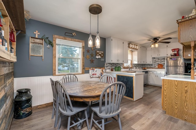 dining area with ceiling fan, sink, and light hardwood / wood-style floors