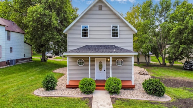 view of front property with covered porch, central AC unit, and a front lawn