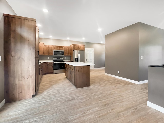 kitchen featuring light wood-type flooring, appliances with stainless steel finishes, and a kitchen island