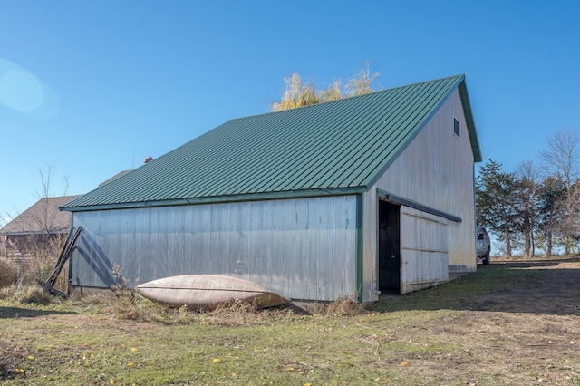 view of property exterior with an outdoor structure and a lawn