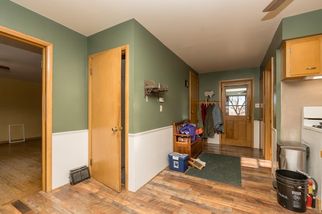 foyer entrance with wood walls and light wood-type flooring