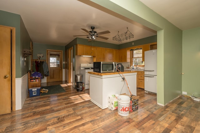 kitchen featuring sink, white fridge, range, ceiling fan, and dark wood-type flooring