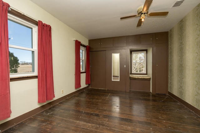 empty room with ceiling fan and dark hardwood / wood-style floors