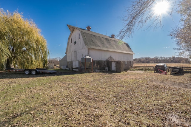 view of side of home featuring a yard and an outbuilding