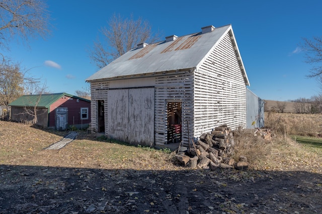 view of side of home featuring an outbuilding