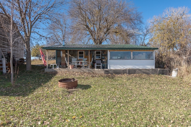 view of front of property featuring a front yard, a patio area, and a fire pit