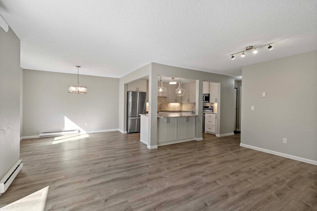 unfurnished living room featuring dark wood-type flooring, a chandelier, a textured ceiling, and a baseboard heating unit