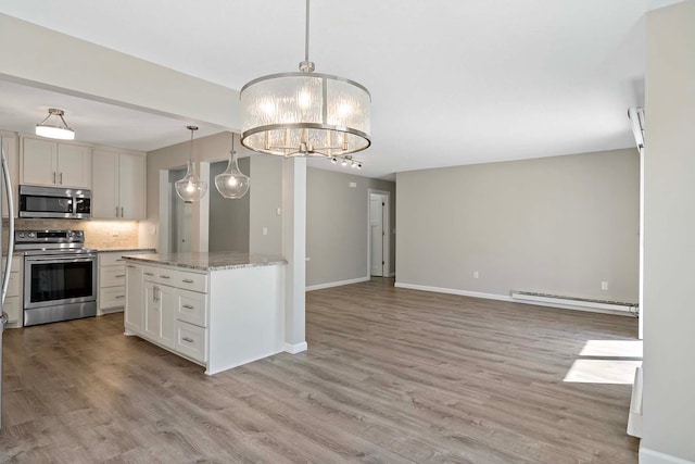 kitchen with white cabinetry, appliances with stainless steel finishes, baseboard heating, light hardwood / wood-style flooring, and pendant lighting