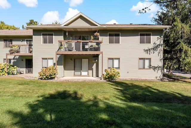 back of property featuring a lawn, a balcony, and a patio area