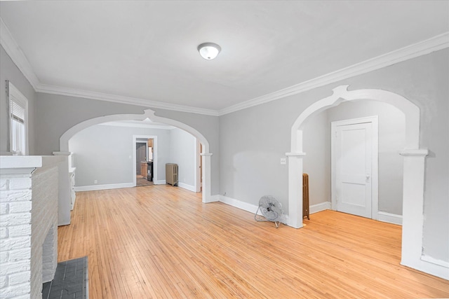 unfurnished living room with crown molding and light hardwood / wood-style floors