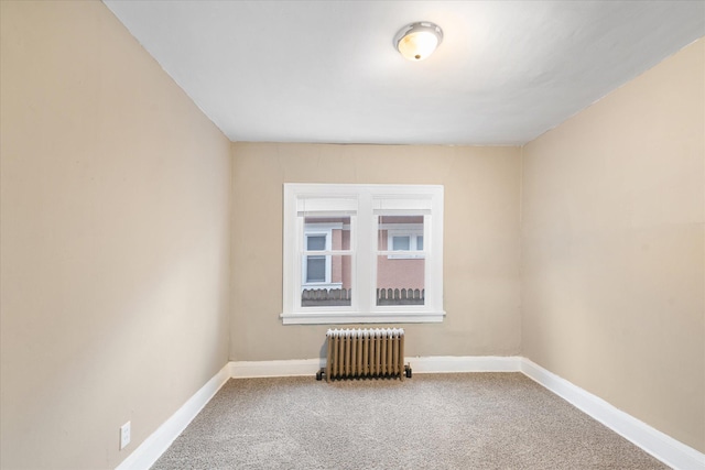 unfurnished room featuring radiator and carpet floors