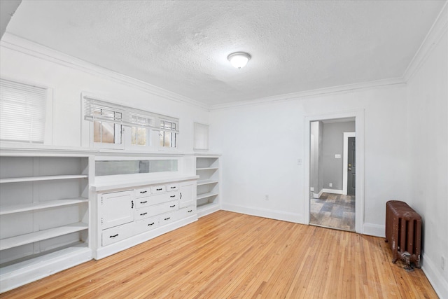 interior space with radiator heating unit, a textured ceiling, light hardwood / wood-style floors, and crown molding