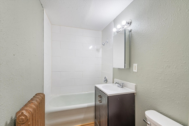 full bathroom with vanity, toilet, tiled shower / bath combo, and a textured ceiling