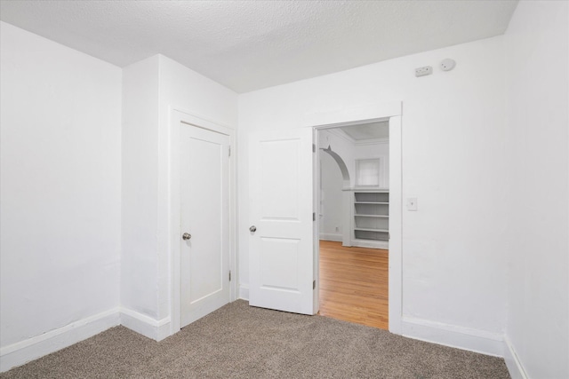 carpeted empty room featuring a textured ceiling