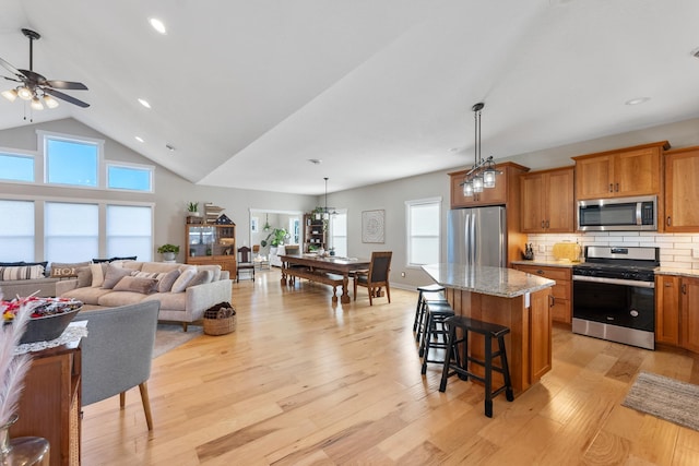 kitchen featuring a kitchen island, decorative light fixtures, light hardwood / wood-style floors, and stainless steel appliances