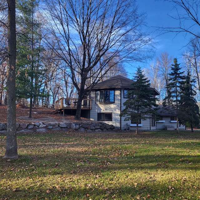 exterior space with a wooden deck and a front lawn