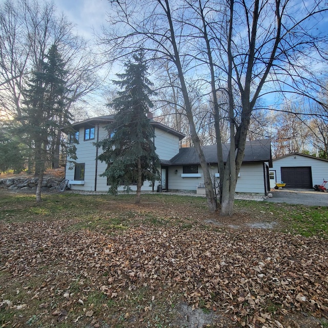 view of front of home with a garage and an outbuilding