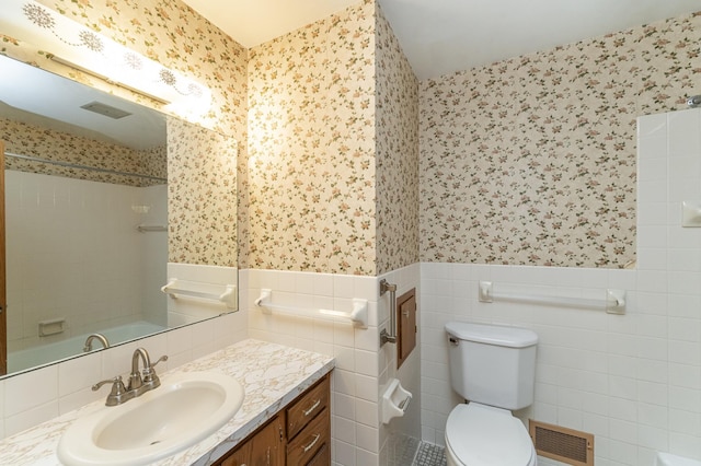 bathroom featuring vanity, toilet, tile walls, and walk in shower