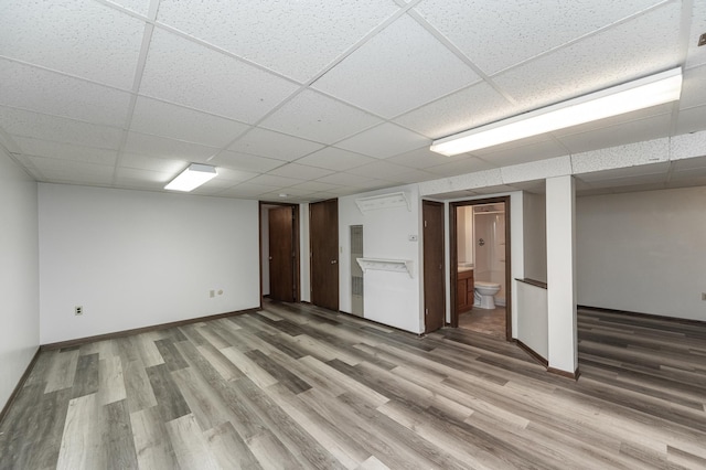 basement with wood-type flooring and a drop ceiling