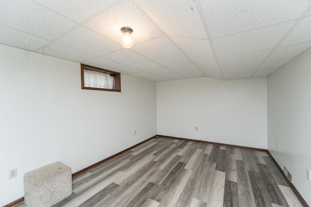 basement with a drop ceiling and wood-type flooring