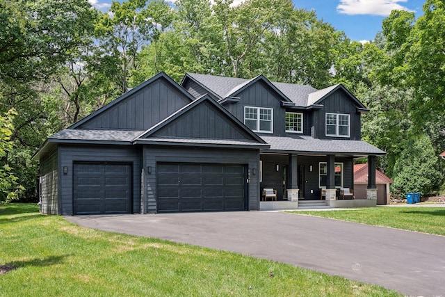 craftsman-style home with a garage, covered porch, and a front lawn