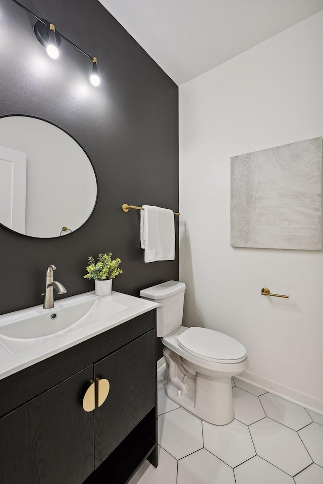 bathroom with toilet, vanity, and tile patterned flooring