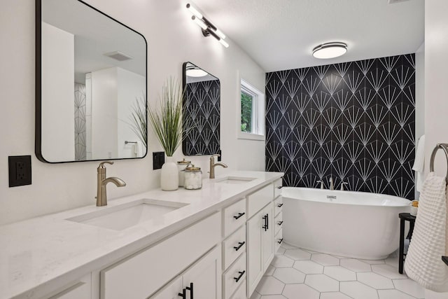 bathroom with vanity, a bath, tile walls, and a textured ceiling