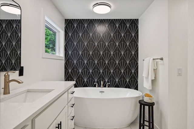 bathroom with vanity, a washtub, and tile walls