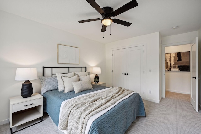 bedroom featuring a closet, light colored carpet, and ceiling fan