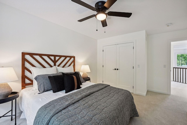 bedroom with ceiling fan, a closet, and light colored carpet