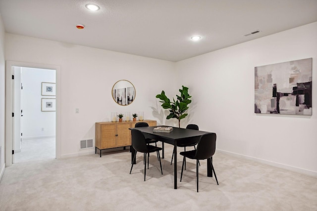 dining area featuring light colored carpet