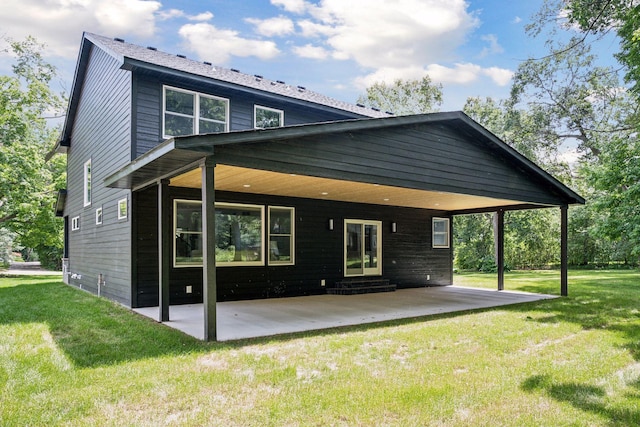 back of house with a yard and a patio