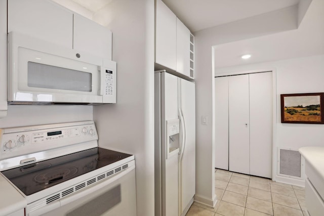 kitchen featuring white appliances, white cabinetry, and light tile patterned flooring