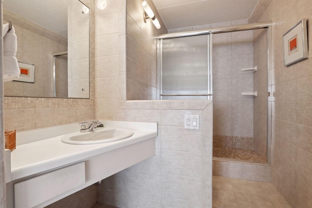 1920 1st St Unit 2001, Minneapolis, MN 55454 - bathroom with tile walls, tiled shower, vanity, tile patterned flooring, and a textured ceiling