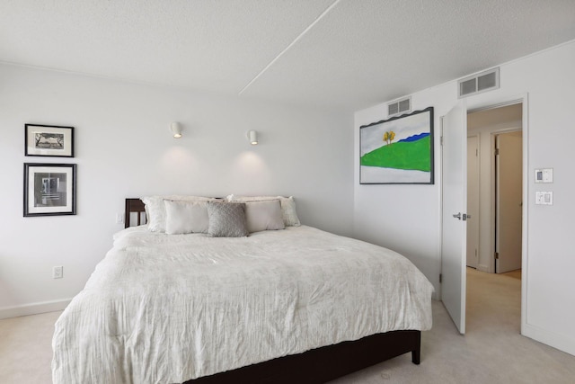 bedroom featuring light carpet and a textured ceiling