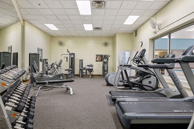 gym with a drop ceiling and a towering ceiling