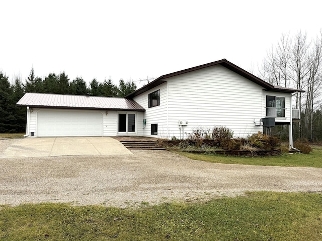 view of front facade featuring a front yard, a balcony, and a garage