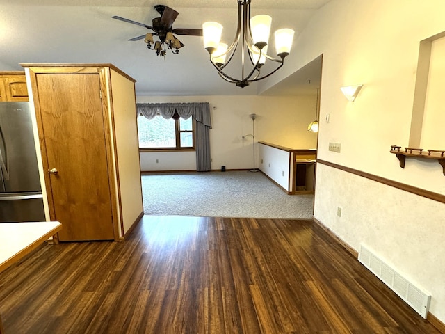 unfurnished dining area featuring ceiling fan with notable chandelier, dark hardwood / wood-style flooring, and lofted ceiling