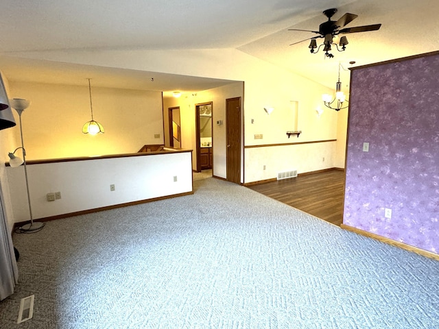 unfurnished room with vaulted ceiling, ceiling fan, and dark wood-type flooring