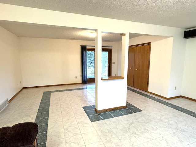 unfurnished room with tile patterned flooring and a textured ceiling